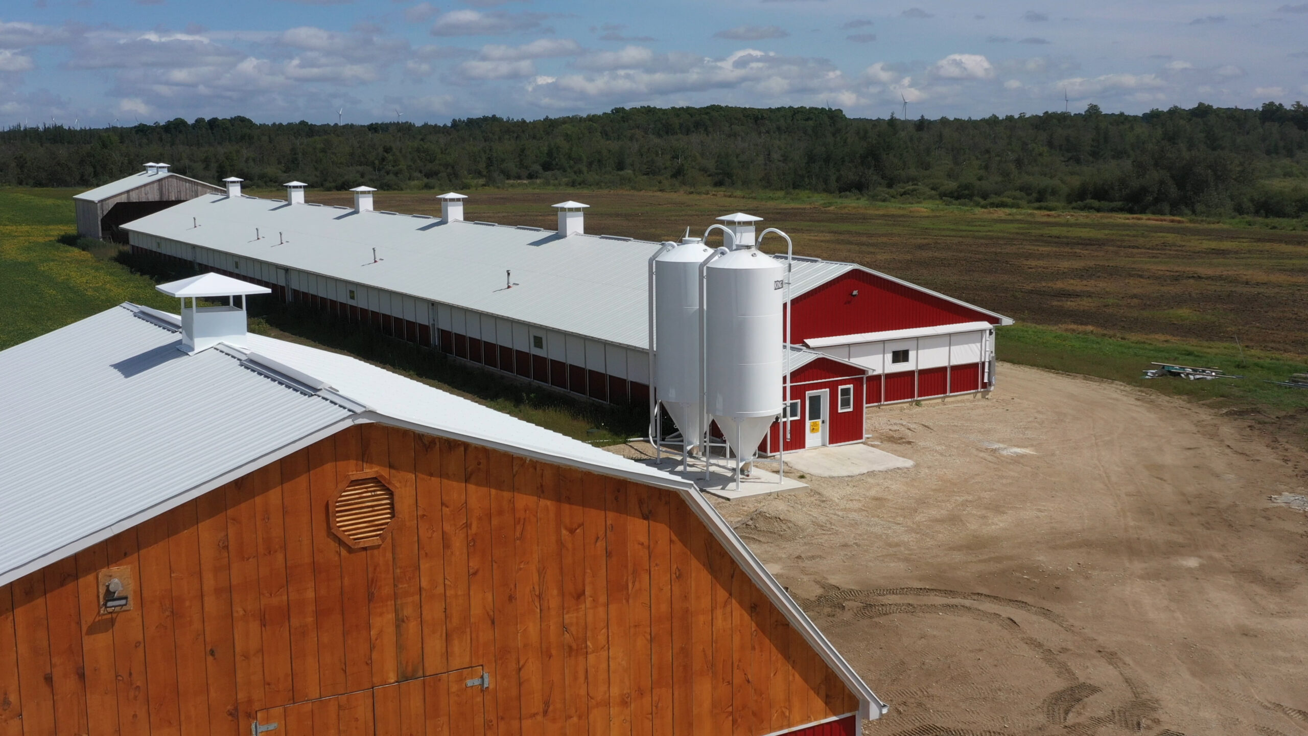 Image of a red barn with two feed bins